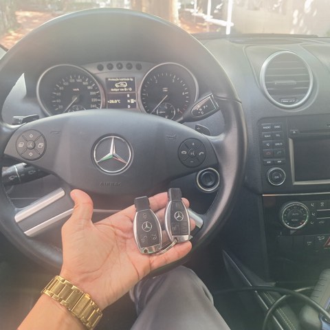 Duas chaves de Mercedes-Benz ML codificadas dentro do veículo, com equipamento de programação ao lado.